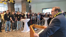 Ein Mann hält eine Rede im Rathaus Foyer