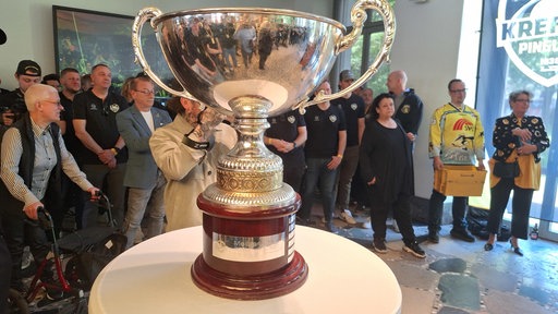 Ein großer Pokal mit zwei Henkeln steht auf einem Tisch