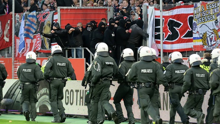 Maskierte Fans aus Essen versuchen den MSV-Platz zu stürmen.