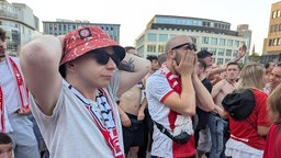 Zwei RWE Fans heben beim ersten Gegentor enttäuscht die Hände über den Kopf