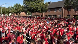Fans, gekleidet in rot und weiß auf dem Weg zum Stadion