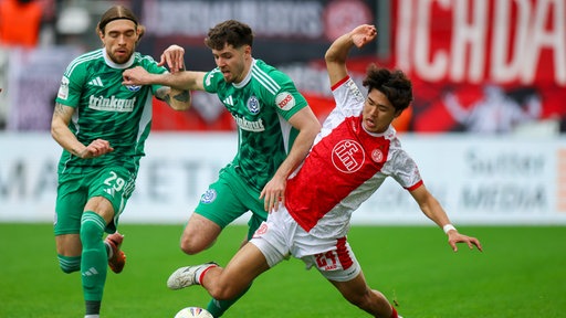  Joshua Bitter (Duisburg, l-r), Tobias Fleckstein (Duisburg) und Kaito Mizuta (Essen) im Kampf um den Ball