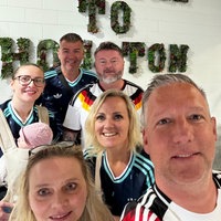 Die Hagener machen bei ihrer Ankunft in Houston ein Selfie und tragen Fußballtrikots, im Hintergrund steht "To Houston" an der Wand.