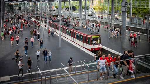 Fans von Fortuna Düsseldorf laufen von der Straßenbahn in Richtung Stadion
