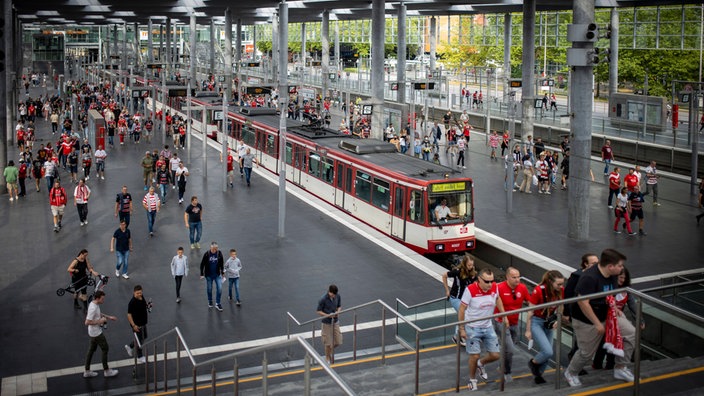 Fans von Fortuna Düsseldorf laufen von der Straßenbahn in Richtung Stadion