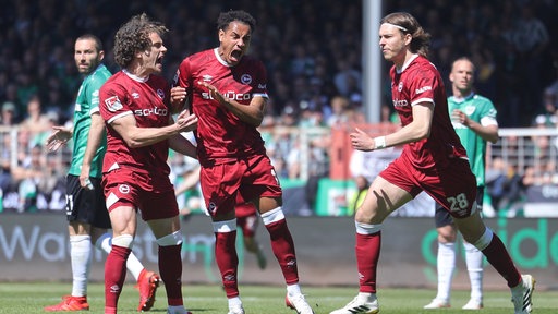 Bielefelds Torschütze Monju Momuluh (3. v. l.) bejubelt seine Treffer im Derby gegen Münster mit Kapitän Mael Corboz (2. v. l.)