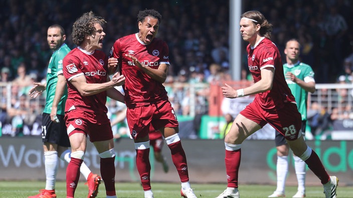 Bielefelds Torschütze Monju Momuluh (3. v. l.) bejubelt seine Treffer im Derby gegen Münster mit Kapitän Mael Corboz (2. v. l.)