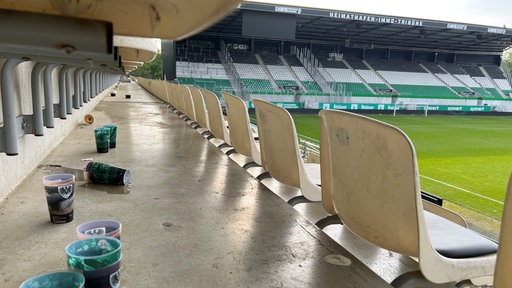 Leere Becher und Zigarettenstummel auf einer Tribüne im Preußenstadion