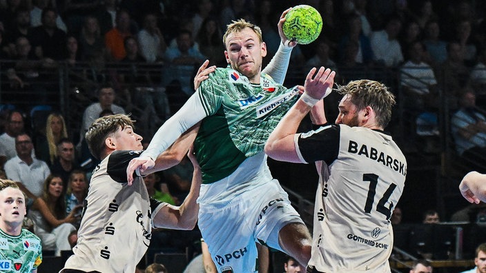  Mathias Gidsel von den Füchsen Berlin gegen zewi Spieler des Bergischen HC