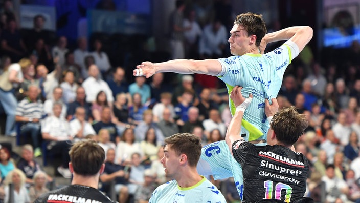 Der Gummersbacher Miro Schluroff (2. v . r.) wirft auf das Tor vom HC Erlangen 