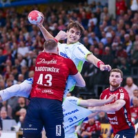 Gummersbachs Julian Köster (2. v. v.) wird von Flensburgs Blaz Blagotinsek (v.) beim Wurf gestört