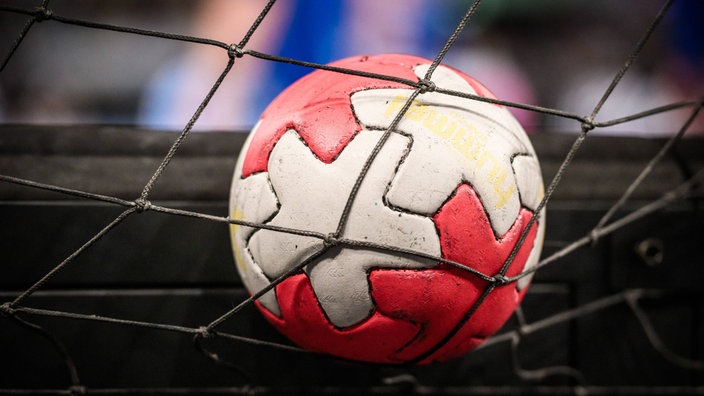Ein Handball liegt auf einem Tornetz.