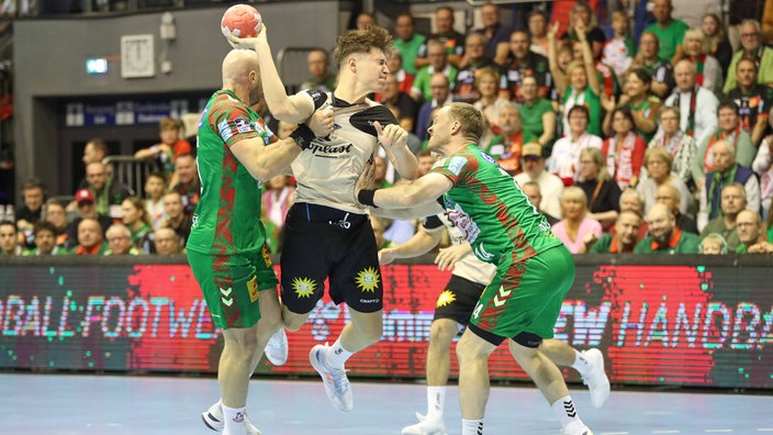Sören Steinhaus vom Bergischen HC im Zweikampf mit zwei Spielern des SC Magdeburg