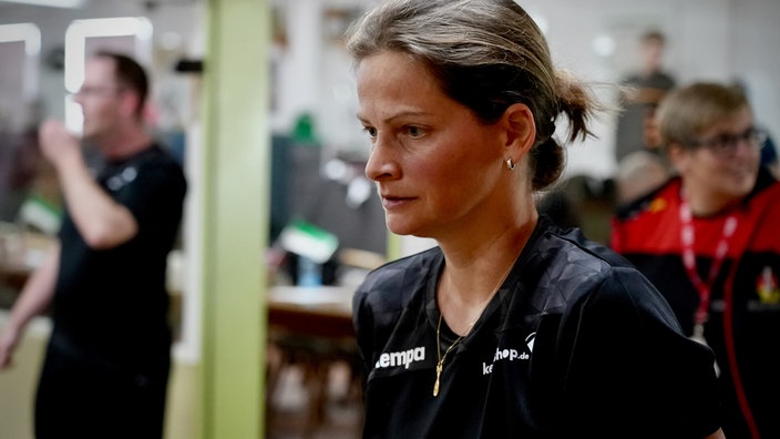 Frau mit dunkel blonden Haare zu einem Zopf zusammengebunden und einem Sportoberteil