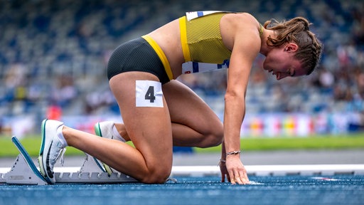 Annkathrin Hoven kniet am Startblock.