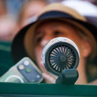 Eine Zuschauerin nutzt einen Gesichtsventilator in einer Loge auf dem Centre Court