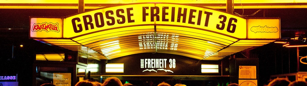 Eine Publikumsansammlung vor dem hell erleuchteten Einlass zur Grossen Freiheit Nummer sechsunddreissig.