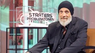 Torrsten Sträter im Studio seiner neuen Show. Hinter ihm der Schriftzug "Sträters Problemzonen"