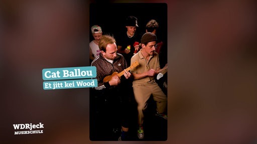 Die Band sitzt in einem engen Studio und spielt auf Kinderinstrumenten