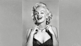 Porträtfoto von Filmikone Marilyn Monroe, die eine Kette um den Hals trägt und in die Kamera lacht (ca. 1952)