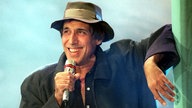 Adriano Celentano mit Hut und Mikrofon