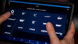 Ein Mann benutzt die ARD-Mediathek App auf einem Tablet