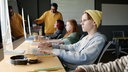 Schüler an PC, gelbe Mütze