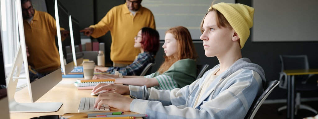 Schüler an PC, gelbe Mütze