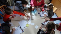 Kinder sitzen um einen Tisch