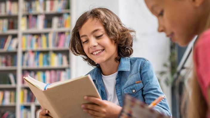 Kinder lesen und machen ihre Hausaufgaben