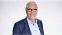 Portrait von Tilman Rauh vor neutralem Hintergrund