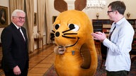 Bundespräsident Frank-Walter Steinmeier bei einer Videoaufzeichung am Vortag der Verleihung mit Maus-Moderator Ralph Caspers und der Maus im Amtszimmer.