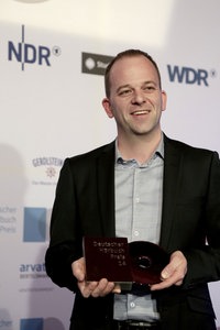 Oliver Bolanz nimmt bei der Verlegerehrung den Preis für das "Beste Sachhörbuch"entgegen.