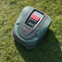 Ein Mähroboter fährt auf einer Wiese
