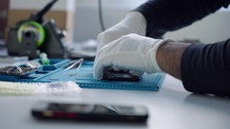 Eine Person demontiert ein altes Handy