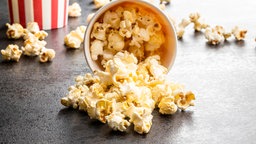 Becher Popcorn, der umgekippt auf dem Tisch liegt