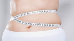 Das Bild zeigt einen Bauch um den ein Maßband gebunden ist.