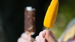 Zwei Personen halten jeweils ein Eis am Stiel.