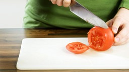 Messer schneidet Tomate