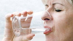 Frau trink aus Wasserglas
