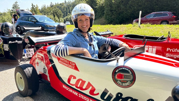 Judith Rakers mit Helm sitzt in einem kleinen offenen vierrädrigen Fahrzeug