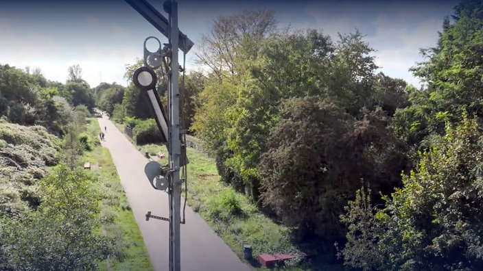 Blick auf den Radschnellweg, im Vordergrund ein altes Signal der Eisenbahnstrecke