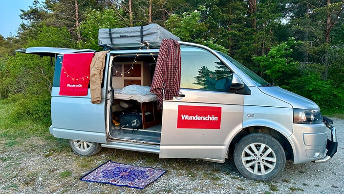 Campervan mit geöffneter Schiebetür und Wunderschön-Aufkleber