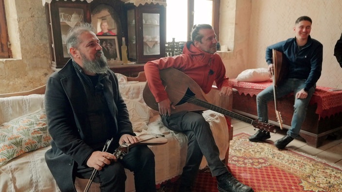 Drei Musiker mit Saiteninstrumenten