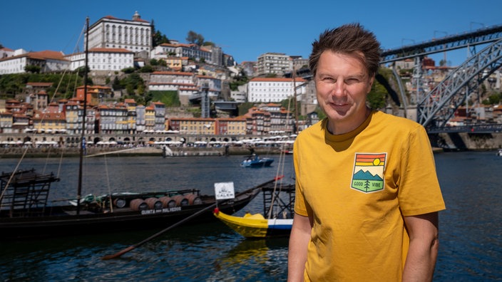 André Gatzke in Porto, im Hintergrund der Fluss Douro und die Dom Louis Brücke.