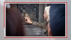Frau berührt einen Hund auf einem Relief
