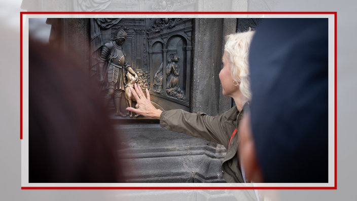 Frau berührt einen Hund auf einem Relief