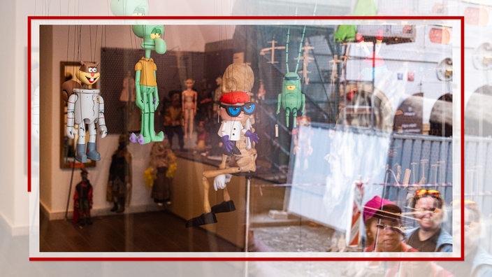 Spiegelung in einem Schaufenster mit Marionetten