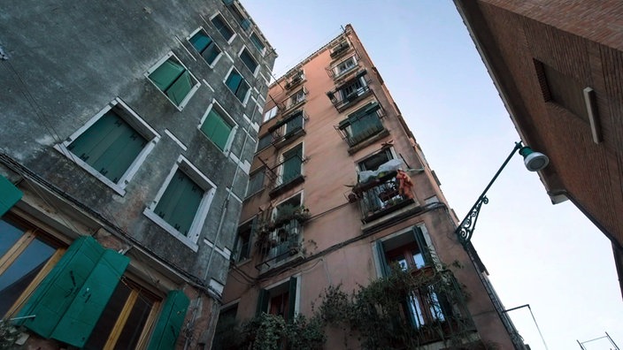 Blick von unten nach oben entlang der Fassade eines siebenstöckigen Hauses