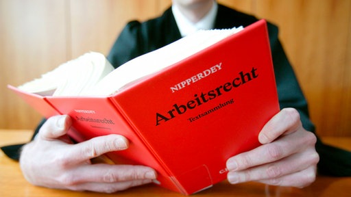Ein Anwalt in einer Robe mit dem Gesetzbuch - Arbeitsrecht 